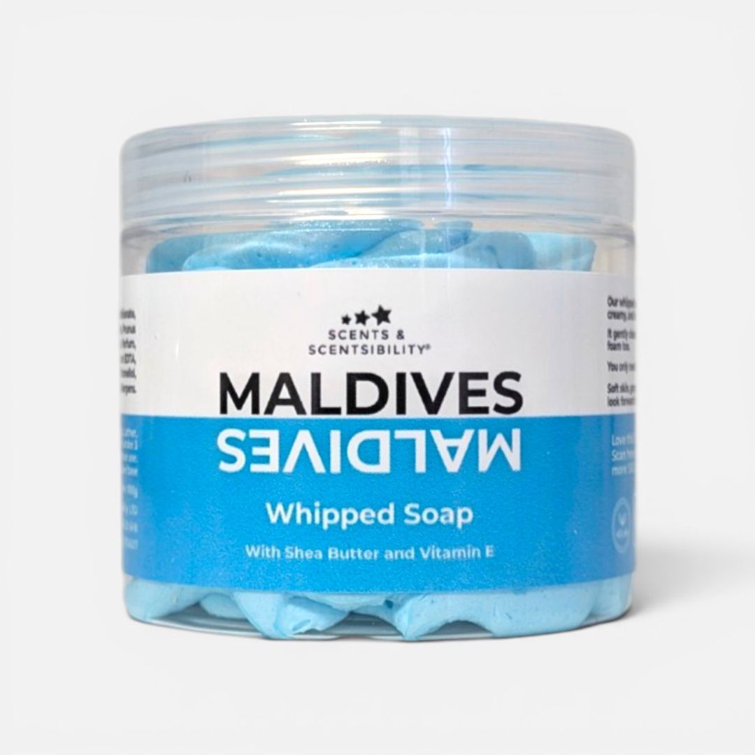 A clear plastic jar of Scents & Scentsibility Maldives Whipped Soap, showing light blue whipped soap inside, with a white and blue label on a light gray background.