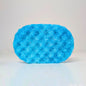 A bright blue textured oval sponge or scrubber standing upright on a light gray studio background.