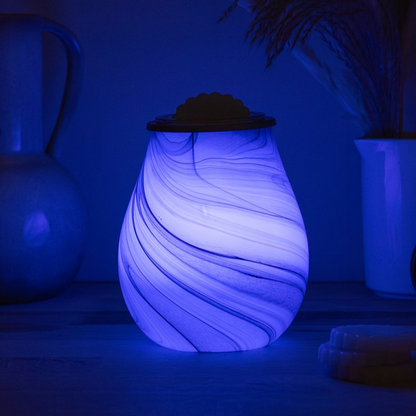 Decorative wax melt warmer wavy pattern glowing in a dark room.