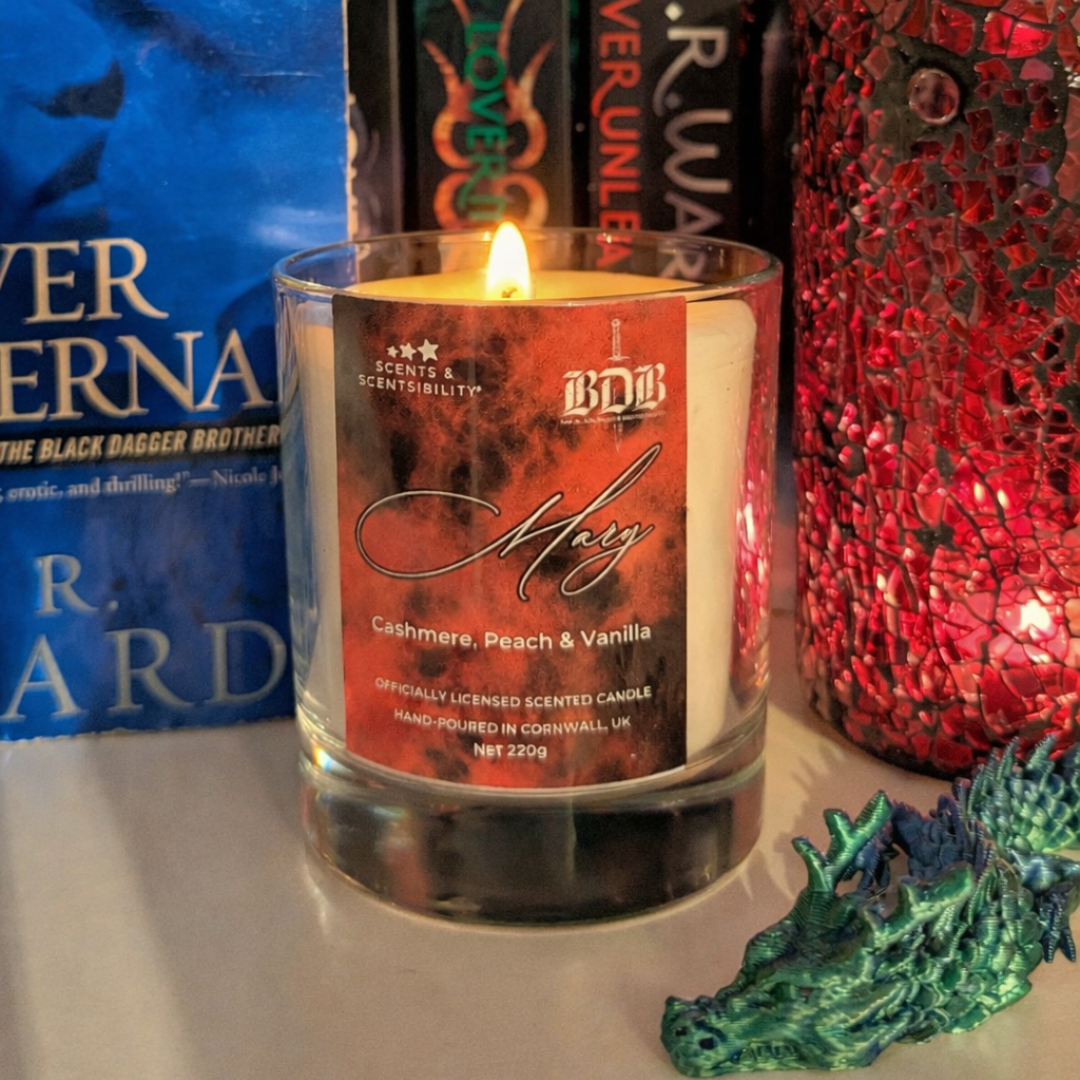 Scented candle with a label in front of books and decorative items