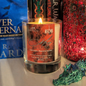 Scented candle with a label in front of books and decorative items