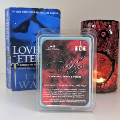 Scented wax melt packaging with a book and candle in the background