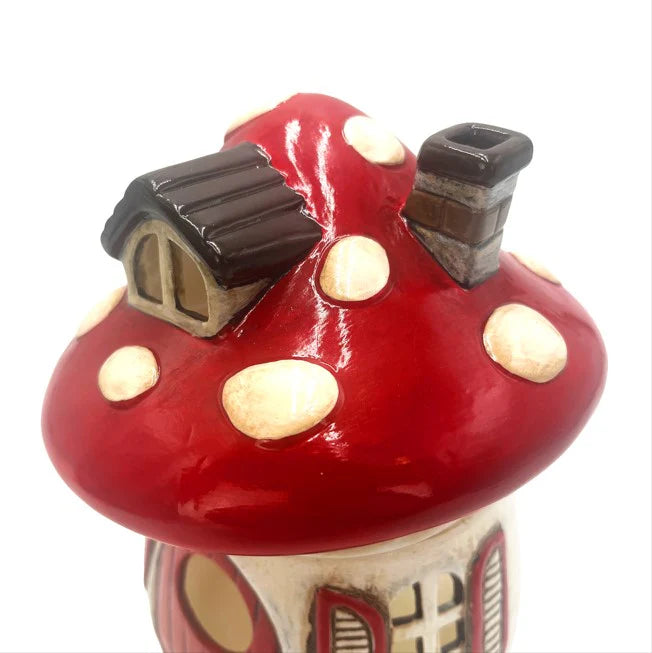 Decorative mushroom-shaped wax melt warmer with a small house on top against a white background