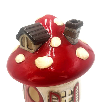 Decorative mushroom-shaped wax melt warmer with a small house on top against a white background