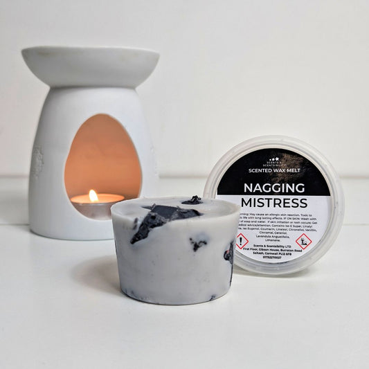Scented wax melt container labeled 'Nagging Mistress' with a wax melt and warmer on a white background