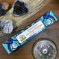 Incense stick packaging with decorative design on a wooden surface with natural elements.