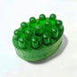 Green massage soap bar with raised massage bumps alongside a matching rectangular soap bar.