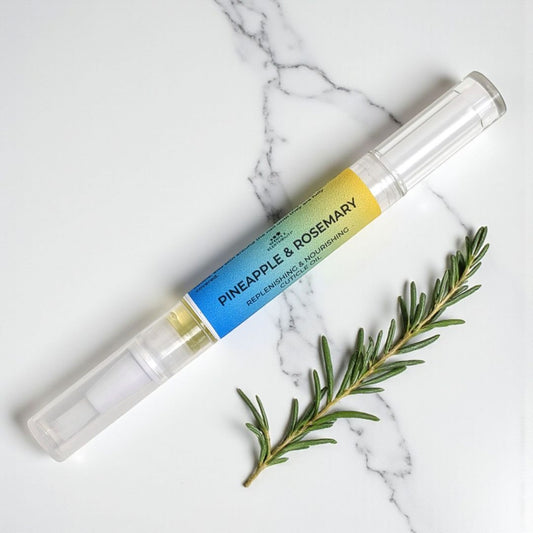 Cuticle Pen with pineapple and rosemary label on a marble surface