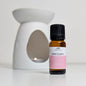 Bottle of 'Pink Fluffy Towels' fragrance oil with a white wax melt burner in the background.