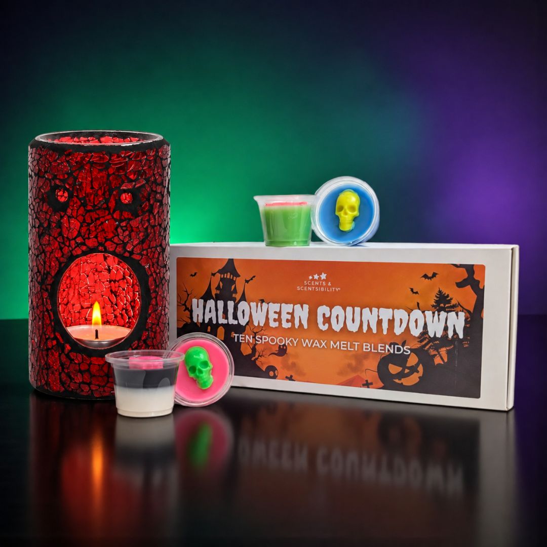 Halloween Countdown wax melt bundle by Scents & Scentsibility, featuring a red crackle wax melt burner with a lit candle, small wax melts in plastic pots, and the product box on a reflective black surface against a green and purple gradient background.