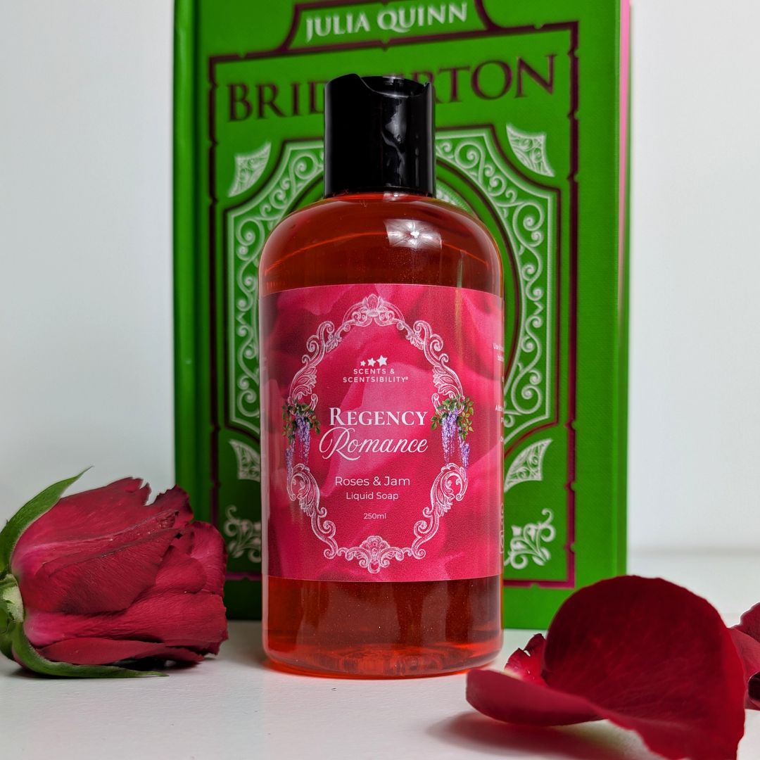 A bottle of liquid soap with a red label, rose petals and a green book. 