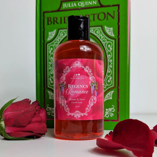 A bottle of liquid soap with a red label, rose petals and a green book. 