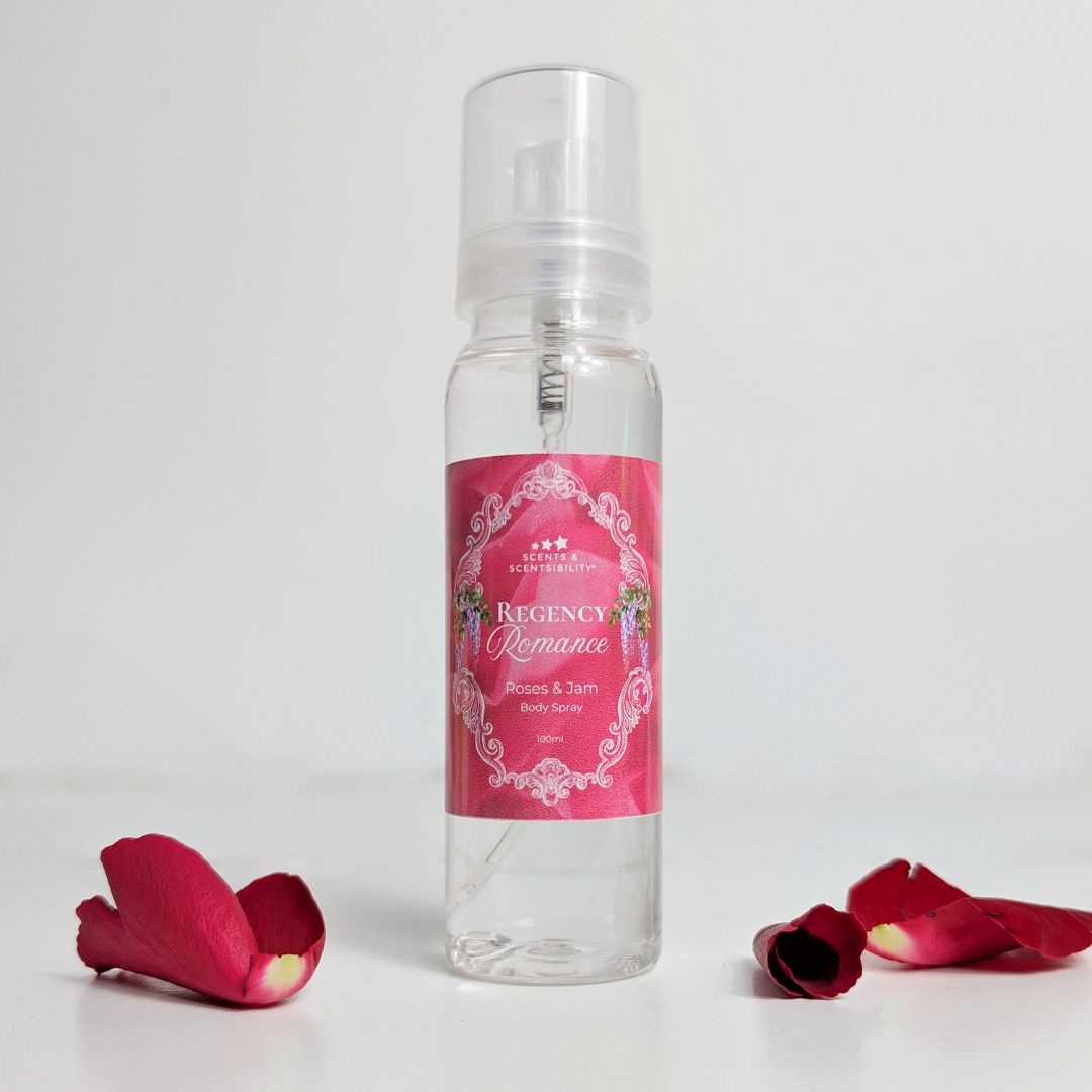 Clear spray bottle with pink label and rose petals on a white background