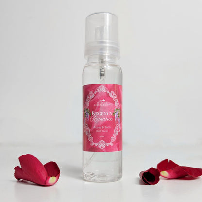 Clear spray bottle with pink label and rose petals on a white background