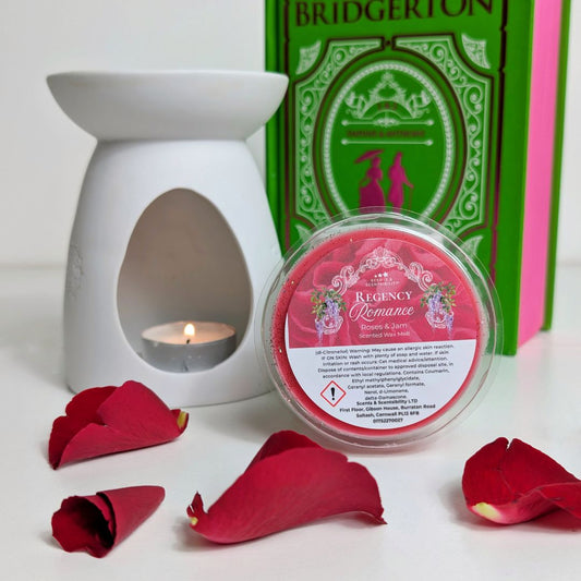 White wax warmer with a lit candle, Bridgerton-themed book, and Regency Romance wax melt with red rose petals on a white background.