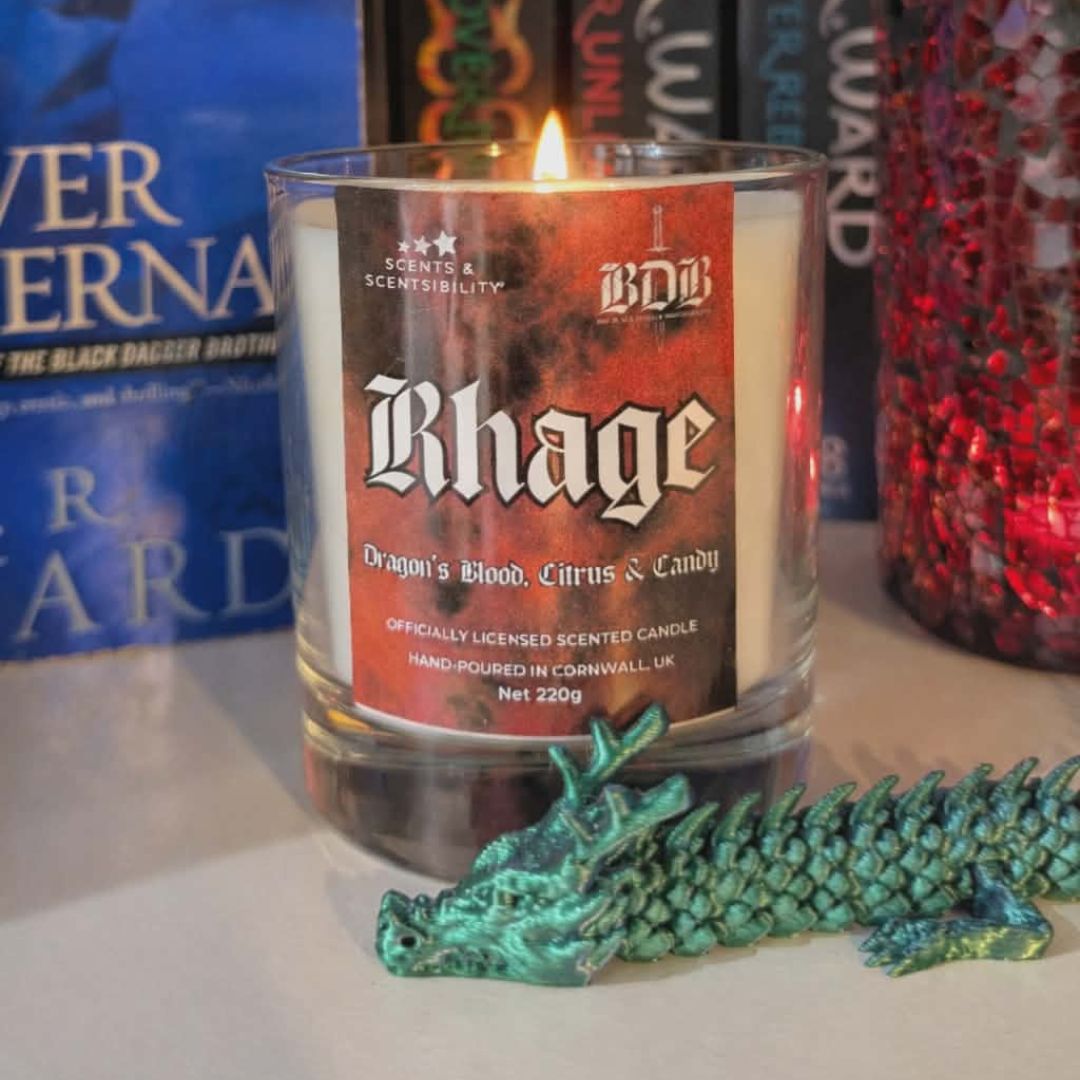 Candle labeled 'Rhage' with a dragon figurine on a surface