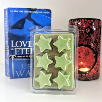 Pack of star-shaped wax melts with a book and candle in the background