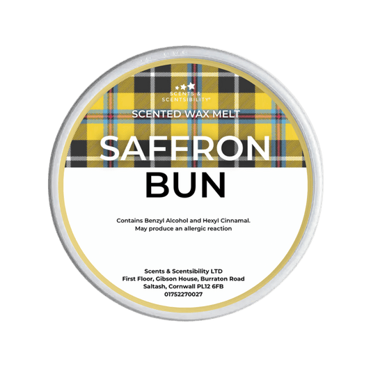 Scented wax melt container labeled 'Saffron Bun' with tartan pattern on a green background