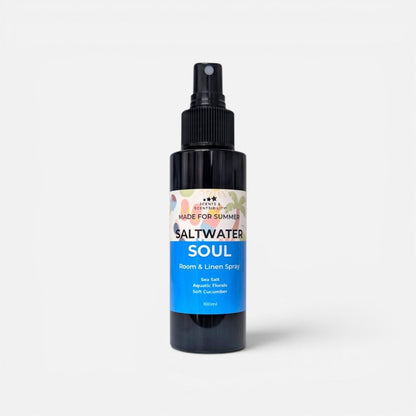 A black plastic spray bottle of 'Saltwater Soul' room and linen spray by 'Made For Summer', featuring a blue and white label, set against a plain light gray background.