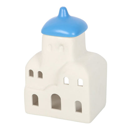 Decorative ceramic house shaped oil burner with a blue roof on a white background