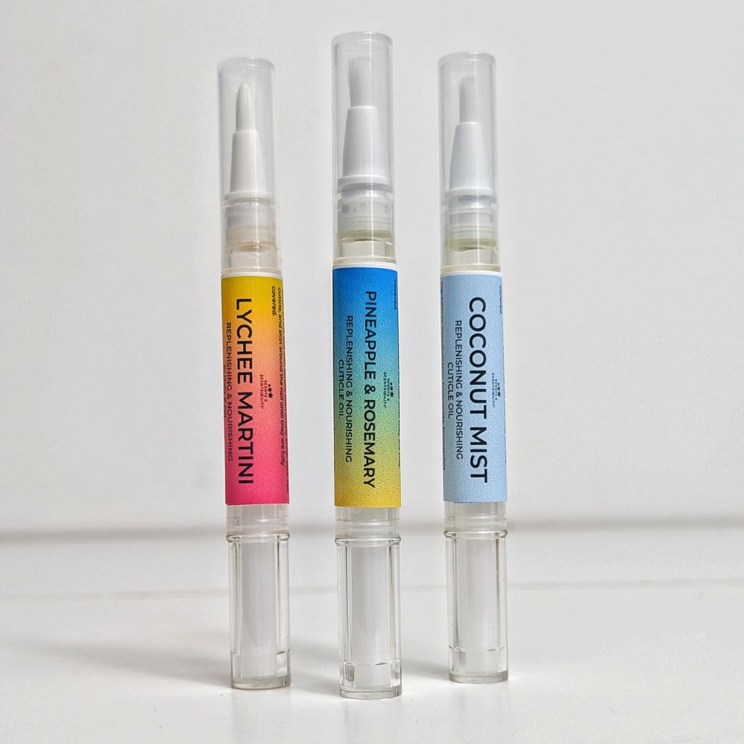 Three cuticle oil pens with colorful labels on a white background