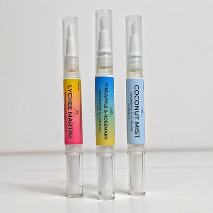 Three cuticle oil pens with colorful labels on a white background