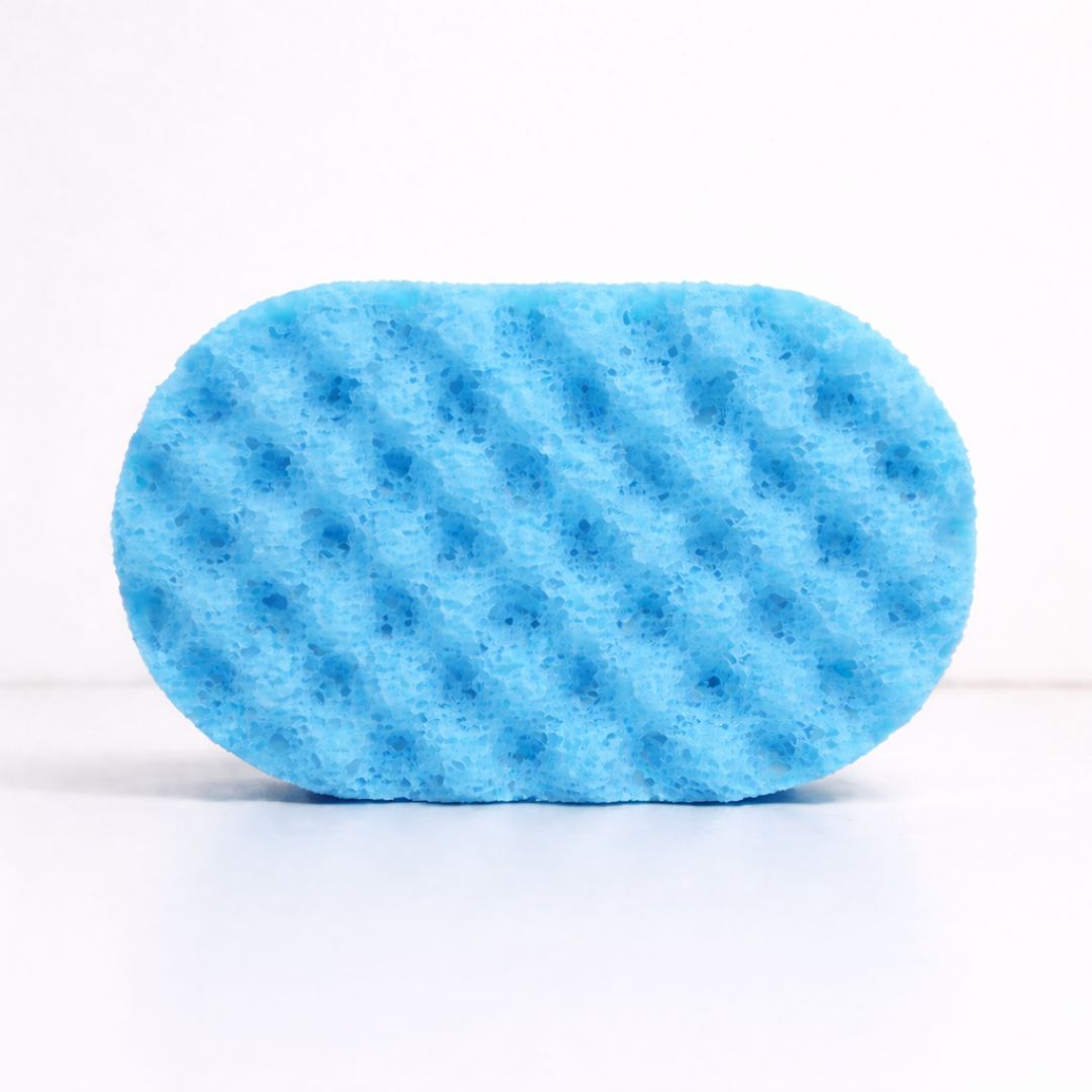A blue textured sponge soaked with soap on a white background