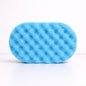 A blue textured sponge soaked with soap on a white background