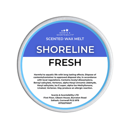 A Scents & Scentsibility 'Shoreline Fresh' scented wax melt, featuring a blue and white label on a solid dark green background.