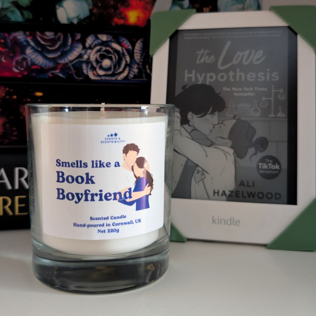 Candle labeled 'Smells like a Book Boyfriend' next to a book titled 'The Love Hypothesis' by Ali Hazelwood.