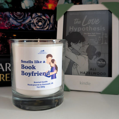 Candle labeled 'Smells like a Book Boyfriend' next to a book titled 'The Love Hypothesis' by Ali Hazelwood.