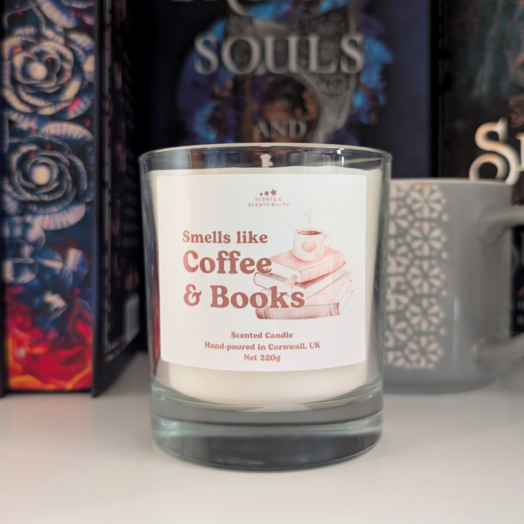 Candle labeled 'Smells like Coffee & Books' with books and a mug in the background