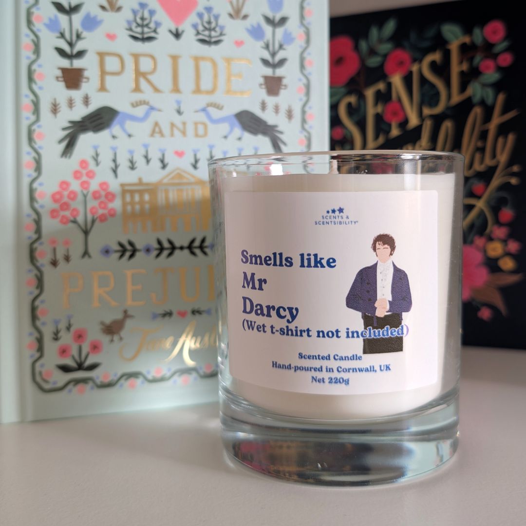 Candle with a label featuring a character from 'Pride and Prejudice' in front of book covers.