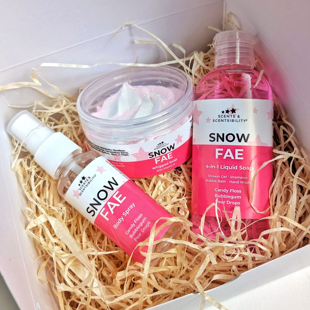 A open gift box filled with wood wool and Snow Fae mini bath & body products