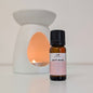 Bottle of 'Soft Rose & Oudh' fragrance oil with an oil burner in the background