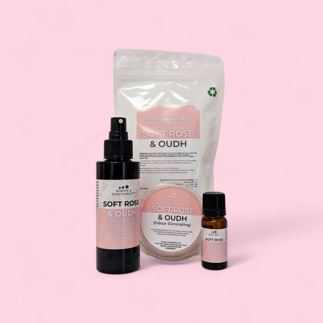 Collection of Soft Rose & Oudh products including a bottle, spray, and essential oil on a pink background.