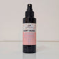 Black spray bottle labeled 'Soft Rose & Oudh' on a light background