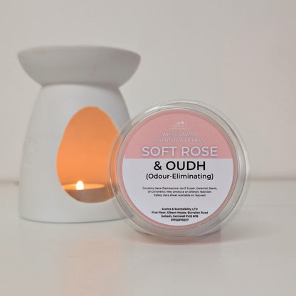 Candle warmer with a lit candle and a container labeled 'Soft Rose & Oudh' on a white background