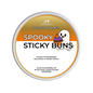 A round tub of Scents & Scentsibility 'Spooky Sticky Buns' scented wax melt, featuring a white and orange label with a cartoon ghost and cake illustration.