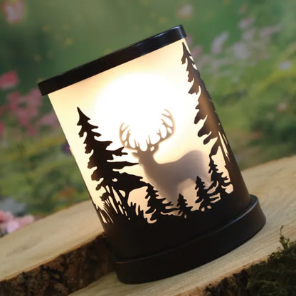 Decorative wax melt warmer with stag silhouette design on a wooden surface
