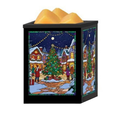 A square black wax melt warmer with a festive Christmas village scene printed on the front and side panels, topped with three golden-yellow wax melts, shown against a plain white background.