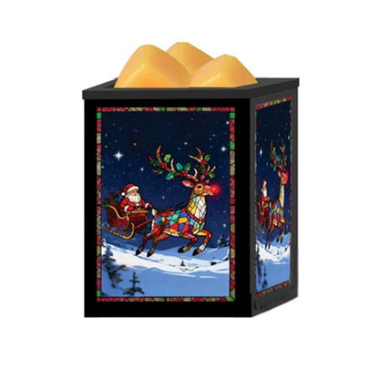 A black cube-shaped Christmas-themed wax melt warmer with yellow wax melts. The front panel features a stained-glass style illustration of Santa Claus in a sleigh pulled by a colorful reindeer under a starry night sky.