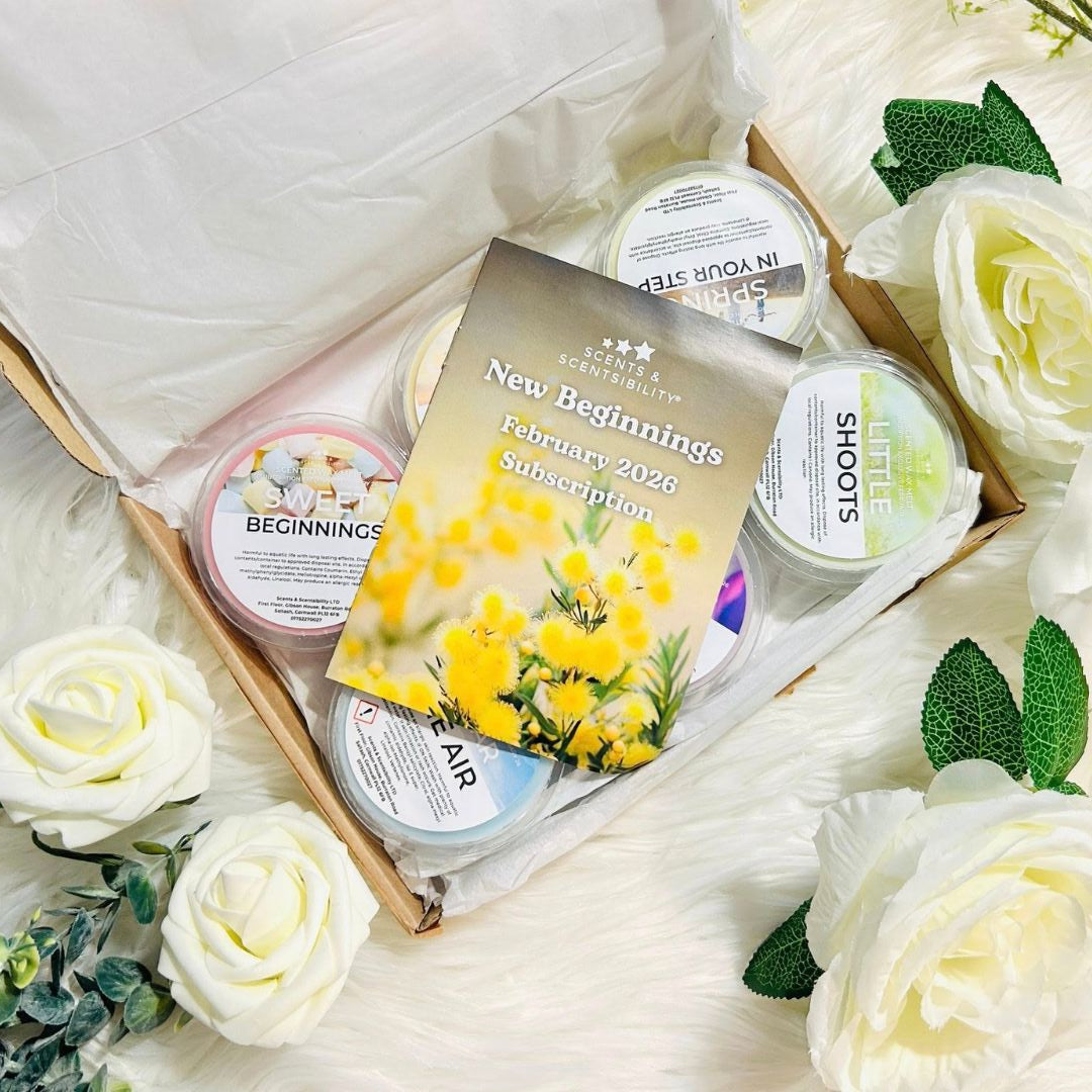 Set of wax melts products in a box with a card, surrounded by white flowers.