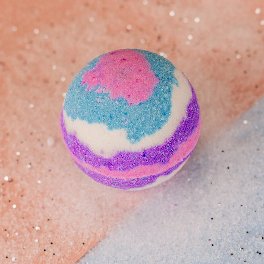 A round bath bomb with white, purple, pink and blue colours. 