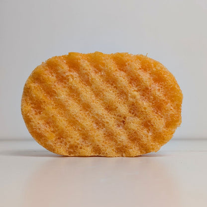 Orange sponge with wavy texture on a white background