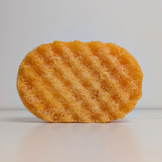 Orange sponge with wavy texture on a white background