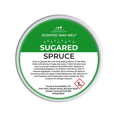 Scented wax melt container labeled 'Sugared Spruce' on a green background