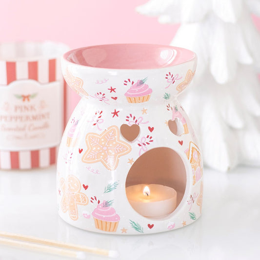 Sugarplum Bakery Gingerbread ceramic wax melt and oil burner with lit tealight, featuring pink details and festive gingerbread, cupcake and candy cane designs.