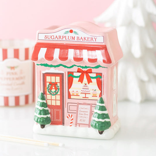 Pink Sugarplum Bakery ceramic wax melt and oil burner, designed as a festive Christmas bakery with red and white awning, Christmas trees and snowy details.