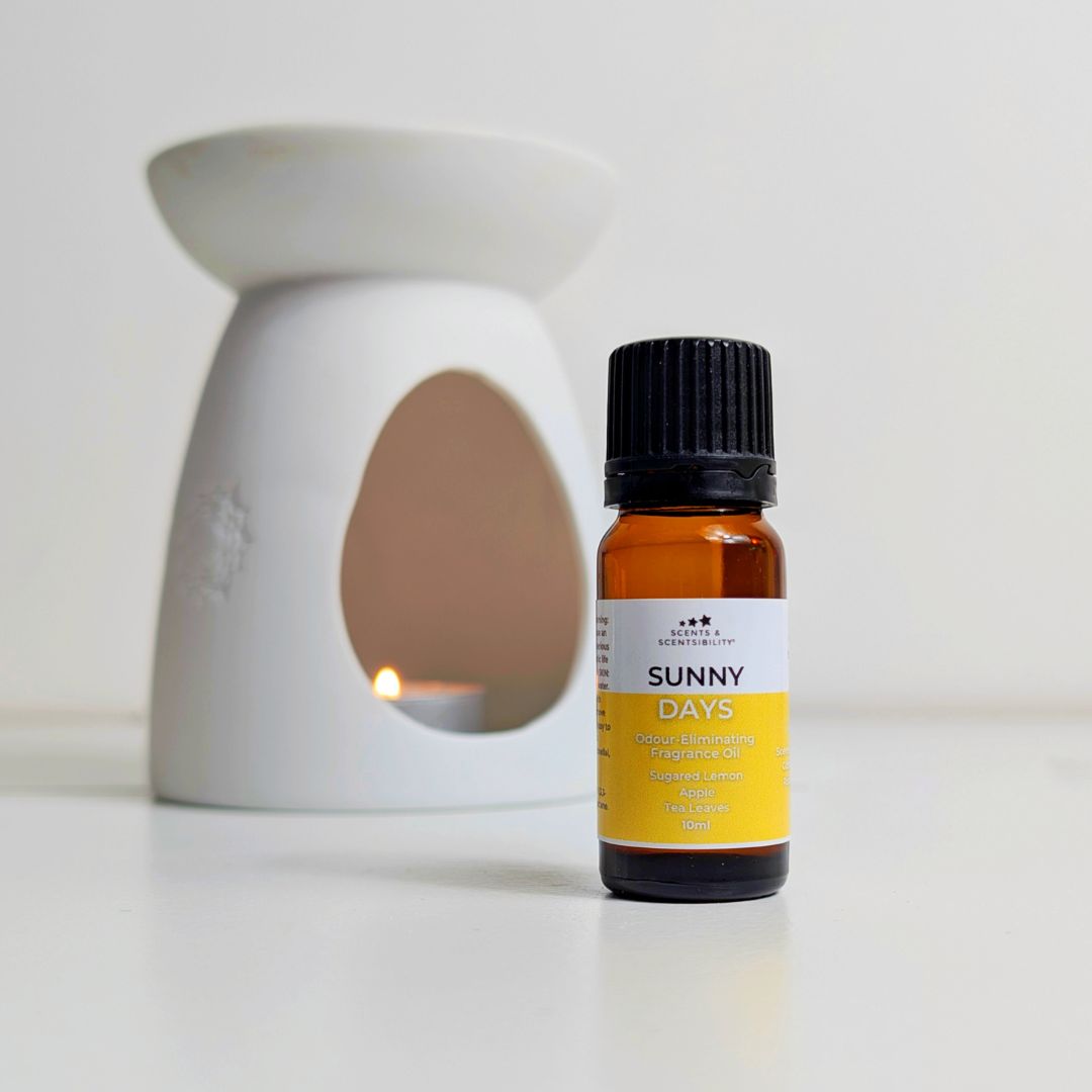 Bottle of fragrance oil labeled 'Sunny Days' with a diffuser in the background.
